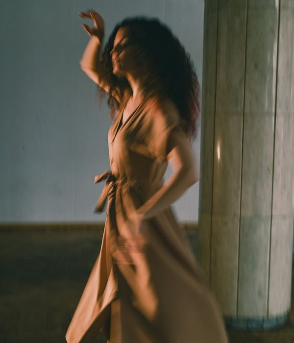 Woman performing a fluid yoga movement, symbolizing energy flow.